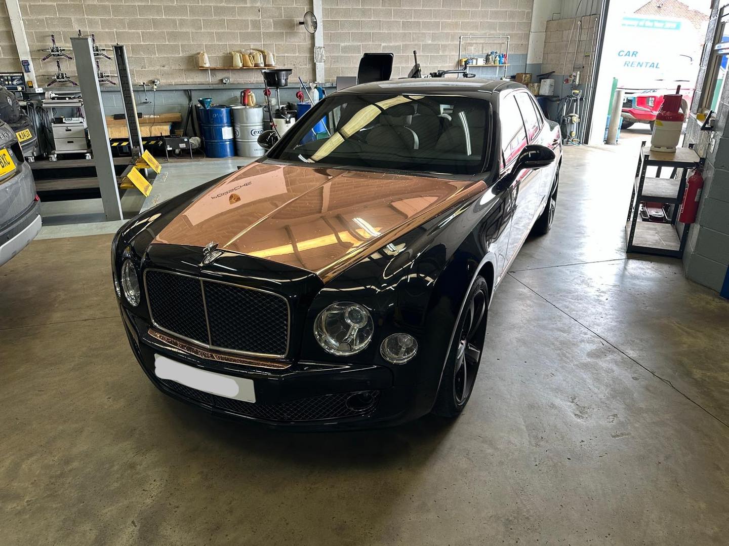 Bentley technician working on blue Bentley