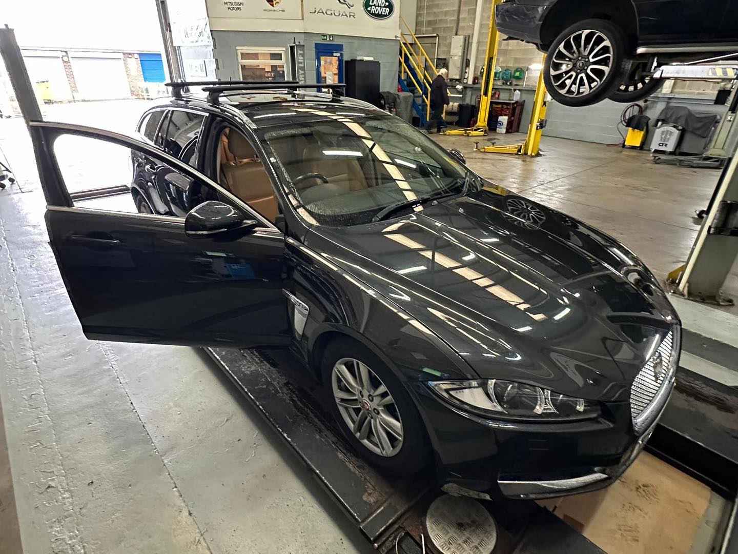 Jaguar technician inspecting luxury sedan at Mitsiland Manchester