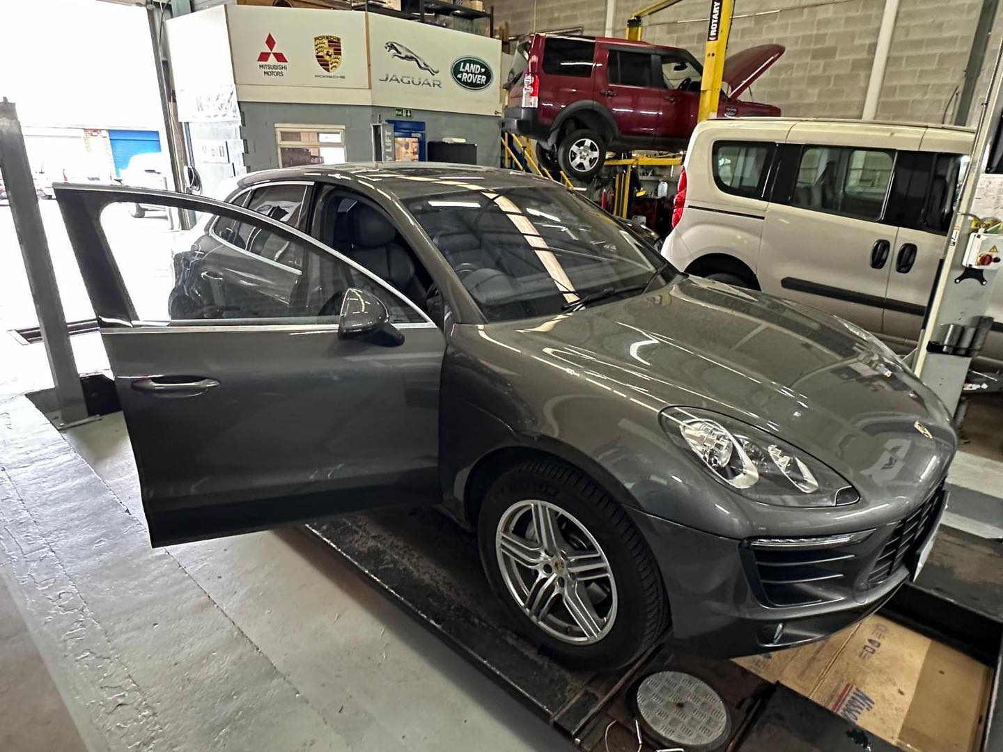 Porsche technician servicing a 911 in Mitsiland workshop